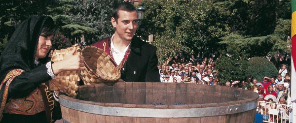 Jóvenes con los trajes típicos volcando uvas en las Fiestas de la vendimia riojana © La Rioja Turismo