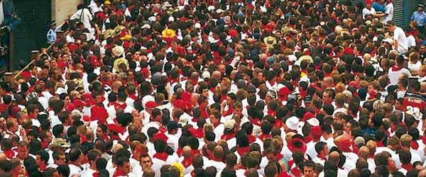 Vista de la multitud vestida con ropa blanca y pañuelo rojo típico de San Fermín. Fiestas de San Fermín. Pamplona ©Turespaña